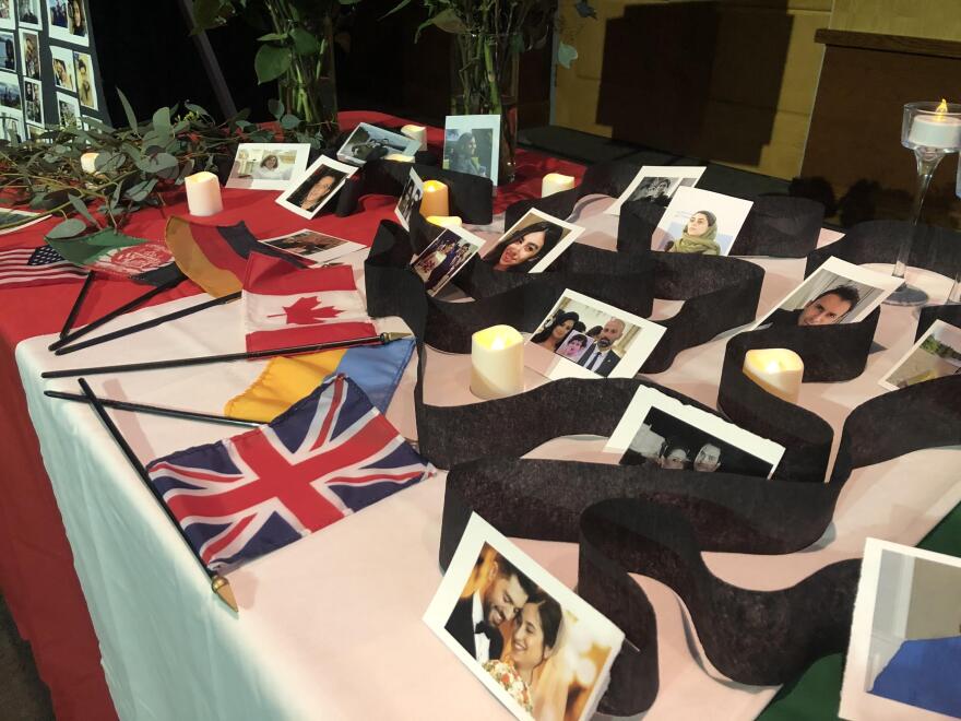 Photos of the plane crash victims and their national flags on display during Monday's vigil.