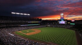 The sun sets over Coors Field in Denver. While summer nights are perfect for baseball, late-season games can get a little chilly.