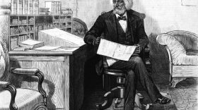 American orator, editor, author, abolitionist and former slave Frederick Douglass (1818 - 1895) edits a journal at his desk, late 1870s.