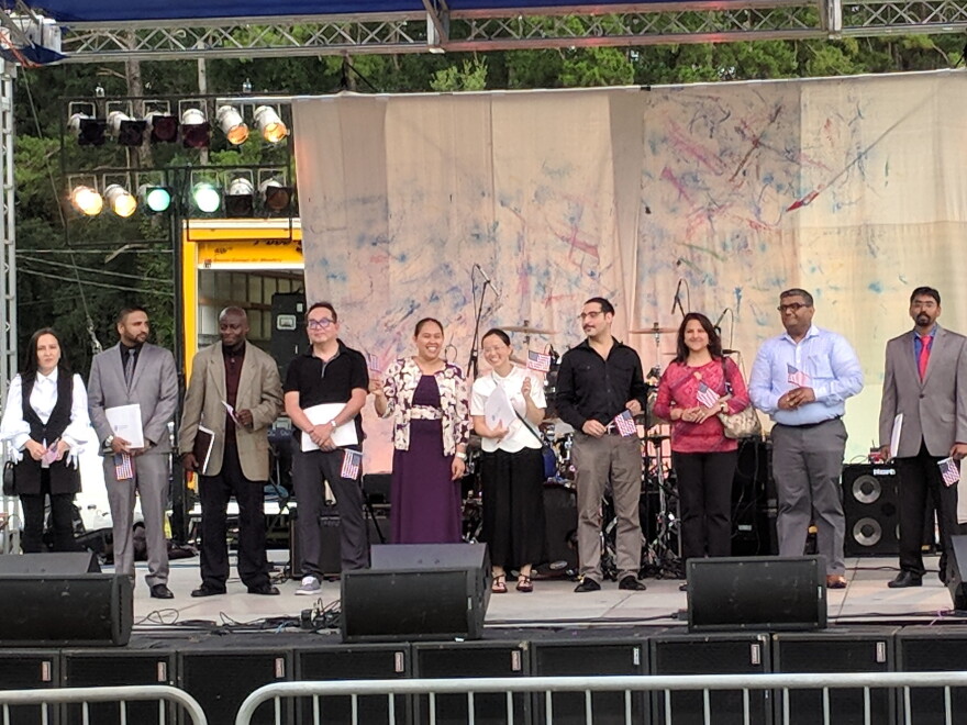 Tallahassee's 10 newest U.S. citizens pose for a group photo on the Celebrate America stage where they'll take the oath of allegiance.