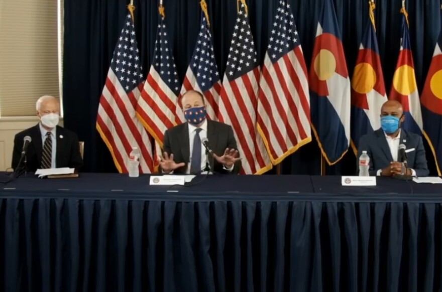 Gov. Jared Polis (center), flanked by Aurora mayor Mike Coffman (left) and Denver mayor Michael Hancock (right), announces a statewide mask mandate on July 16, 2020.