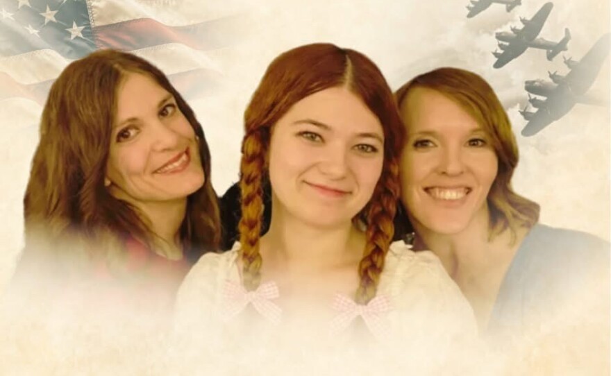 Three women in front of an American flag and war planes