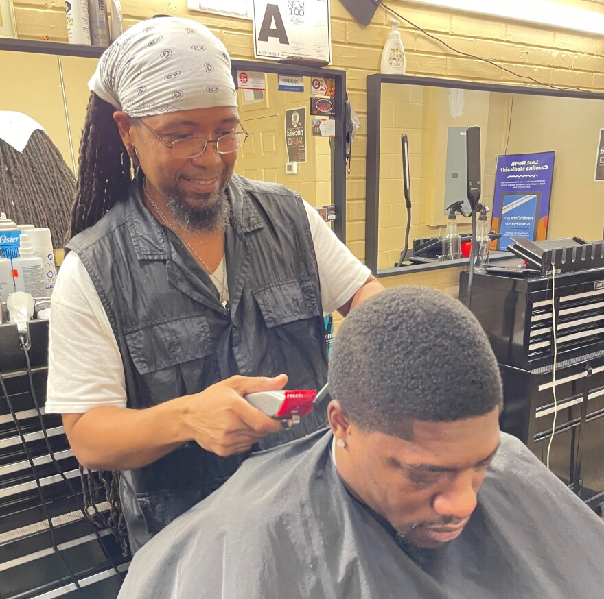 Charles Smith has been a barber for more than 30 years and recently started his own business. His client Raymond Nickerson (seated) just started a janitorial service.