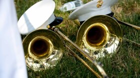 Trombones and hats on grass.