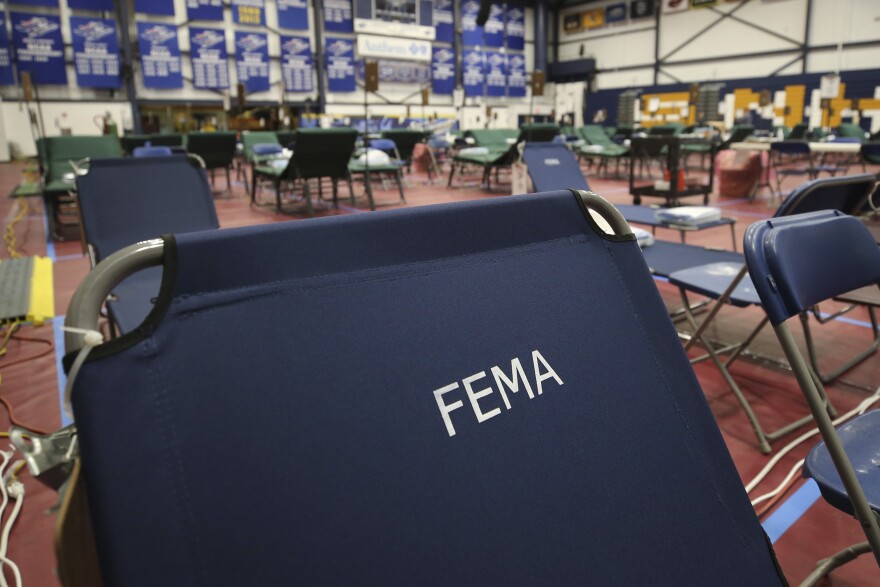FILE photo - A portable cot, with the Federal Emergency Management Agency logo FEMA printed on the backrest, and other cots line the basketball court at a makeshift medical facility in a gymnasium at Southern New Hampshire University in Manchester, N.H., Tuesday, March 24, 2020.