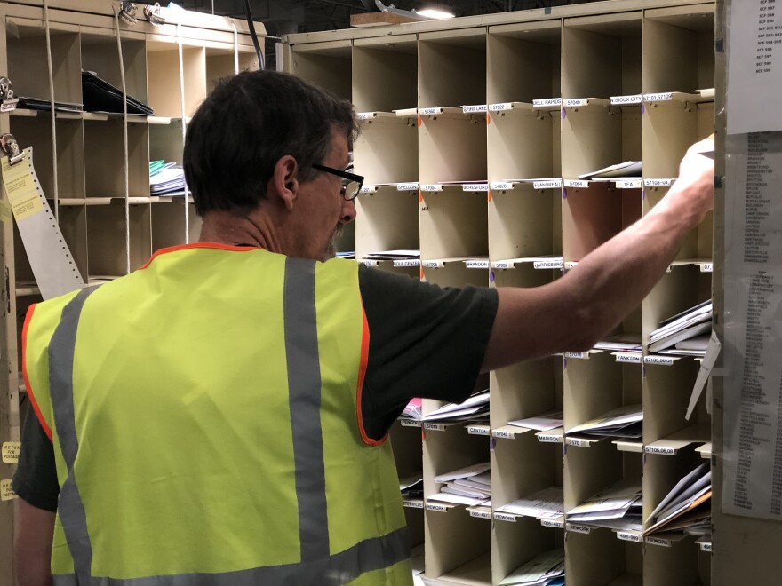 A man sorts mail by hand