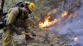 A firefighter builds a containment line as he battles a wildfire Tuesday, Oct. 17, 2017, near Boulder Creek, Calif. (Marcio Jose Sanchez/AP)
