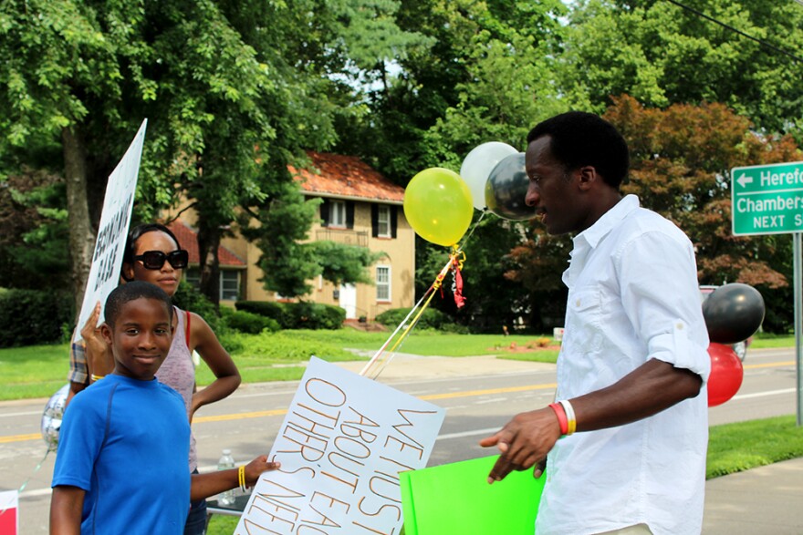 Damion Trasada, right, gathers signs before the walk with his ten-year-old nephew Ahman Trasada.