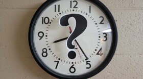 A black question mark centered on a standard analogue clock