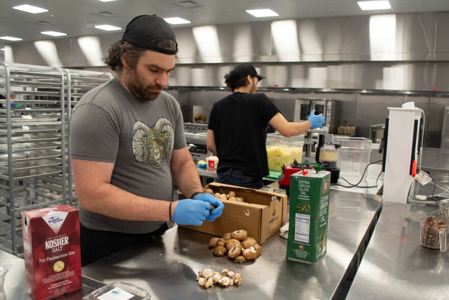 Matt Teriello, left, and Demetrius Brown prep pizza ingredients on a recent Tuesday morning.