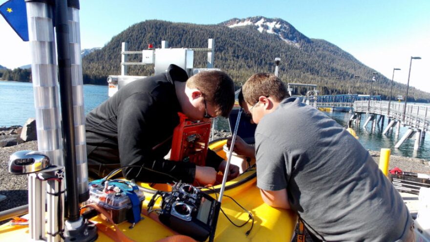 Robotics science students, Nick McComb (left) and Corwin Perren work on the kayak’s electronics box. (Photo/Angela Denning)