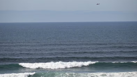 A U.S. Coast Guard helicopter searches the ocean just west of downtown Newport for a twin-engine plane that crashed into the water about 12:45 p.m. Monday.