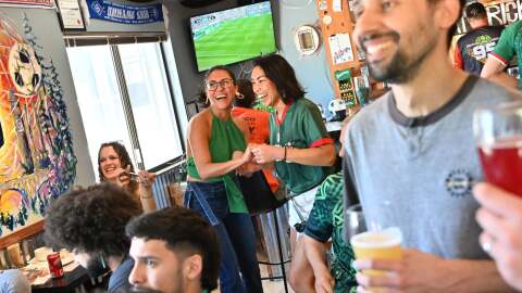 Maybell Torres, left, and Kat Yalung celebrate as they watch Mexico extend their lead against South Africa in the FIFA World Cup on Thursday, Jun 11, 2026, at Hat Trick Brewing in Spokane.
