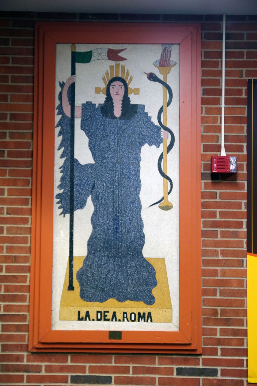 A full-length view of the mural, with the woman standing on a yellow base that reads La.Dea.Roma