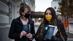 FILE - Sister Palmer 19, right, and Sister Raymundo pose for a portrait with The Book of Mormon while walking around Temple Square in Salt Lake City, Nov. 15, 2020.