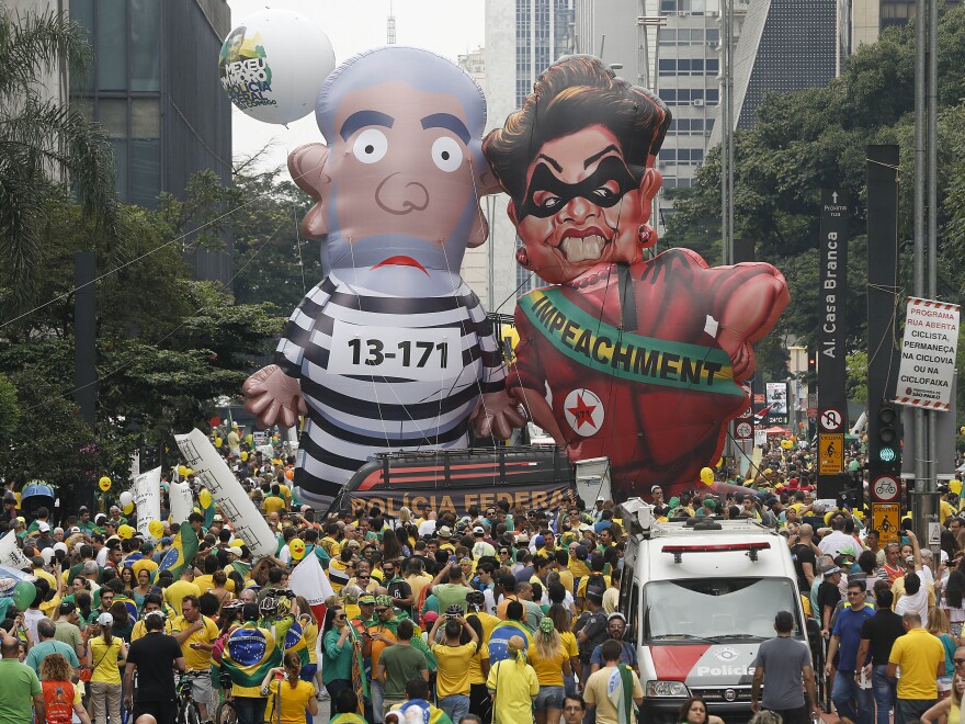 Demonstrators parade large inflatable dolls, depicting Brazil's former President Luiz Inacio Lula da Silva in prison garb and current President Dilma Rousseff dressed as a thief, in Sao Paulo on Sunday. The corruption scandal at the state-run oil giant Petrobras has ensnared key figures from Rousseff's Workers' Party, including Silva, her predecessor and mentor.