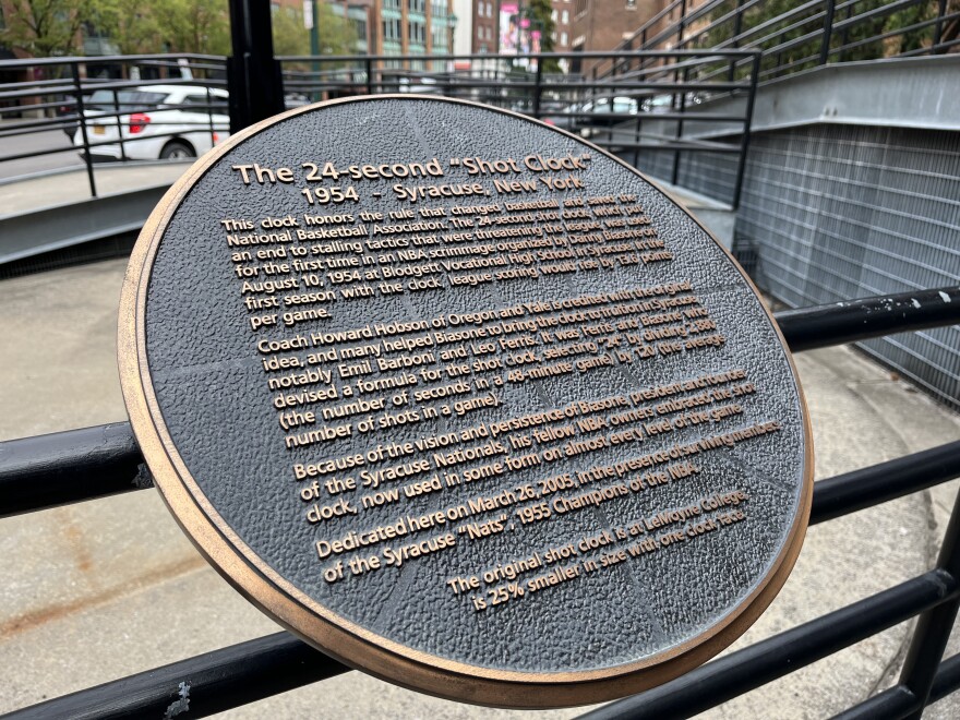 The plaque tells the story behind the shot clock.