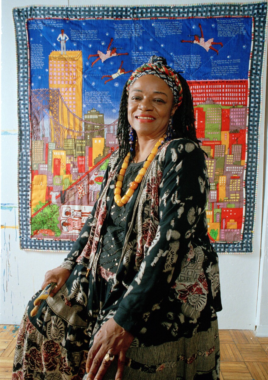 Artist Faith Ringgold sits before her quilt "Tar Beach" in 1993. <em></em>The artwork also inspired a children's book of the same name.