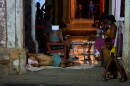 A man sleeps in the doorway of his home while others pass the time trying to cool off in the street in Havana, Cuba, Tuesday, Aug. 4, 2026.