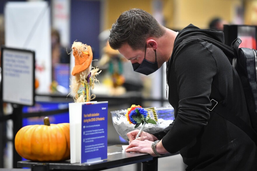 Overland Park resident Darien Lame fills out a luggage tag for his golf clubs inside Terminal B at Kanas City International Airport on Wednesday evening. He said he was headed to Tampa for the holidays to play some golf with a friend and then go see the Kansas City Chiefs play Tampa Bay.