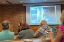 Alyssa O'Brien, a mitigation specialist at the federal defender office in the Western District of Missouri, speaks on Oct. 7 at the University of Missouri about Lance Shockley, pictured in the background.