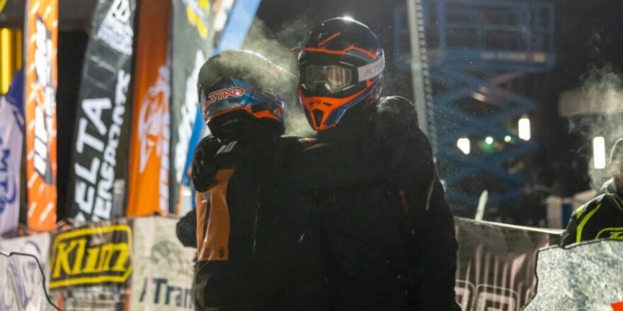 Tyler Aklestad and Nick Olstad embrace moments after crossing the finish line of the 2025 Iron Dog snowmachine race.