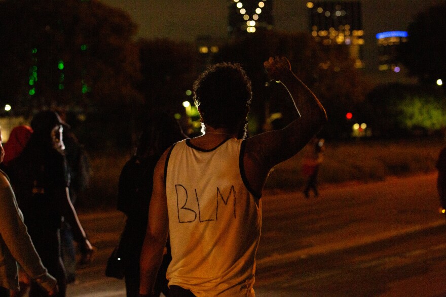 Photo of protester with BLM written on the back of his sleeveless shirt walking down S Lamar St. in Dallas.