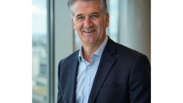 Dr. Robert Steele stands in a blue suit looking at the camera smiling