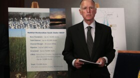 Gov. Jerry Brown waits for the start of a news conference to announce plans to build a giant twin tunnel system to move water from the Sacramento-San Joaquin River Delta to farmland and cities.