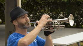 Trumpeter Tom Losce performs Taps. Photo: Mike Abendschein