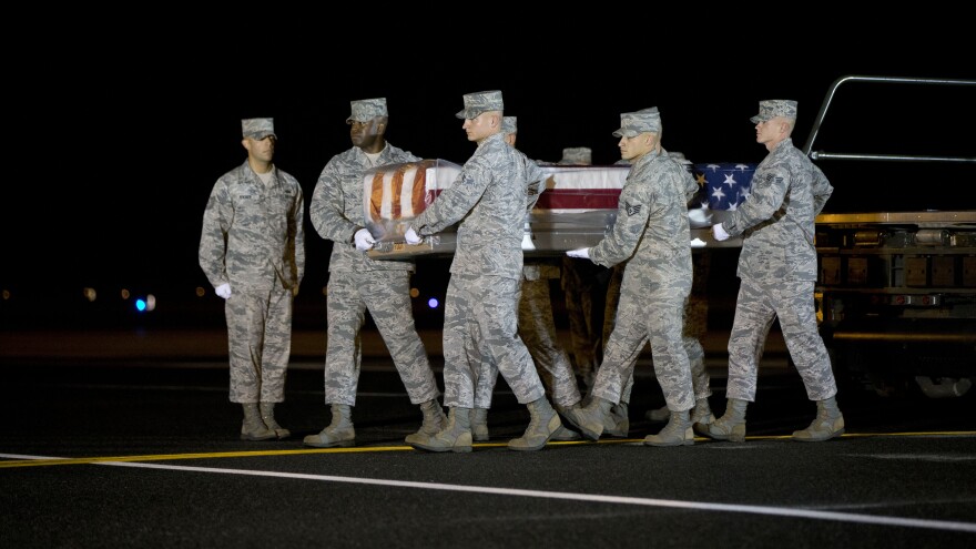 An Air Force team carries the transfer case with the remains of Maj. Phyllis J. Pelky at Dover Air Force Base, Del., on Tuesday. Pelky, 45, was killed two days earlier in a helicopter crash in Afghanistan. Though the U.S. formally ended its combat role in Afghanistan last year, 25 Americans, including military personnel and civilians, have been killed there this year.