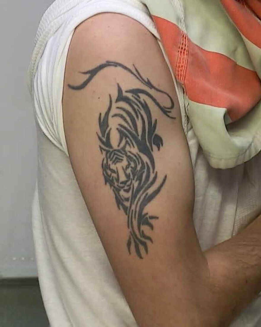 Photo of tiger tattoo on Michael Burham's right arm.