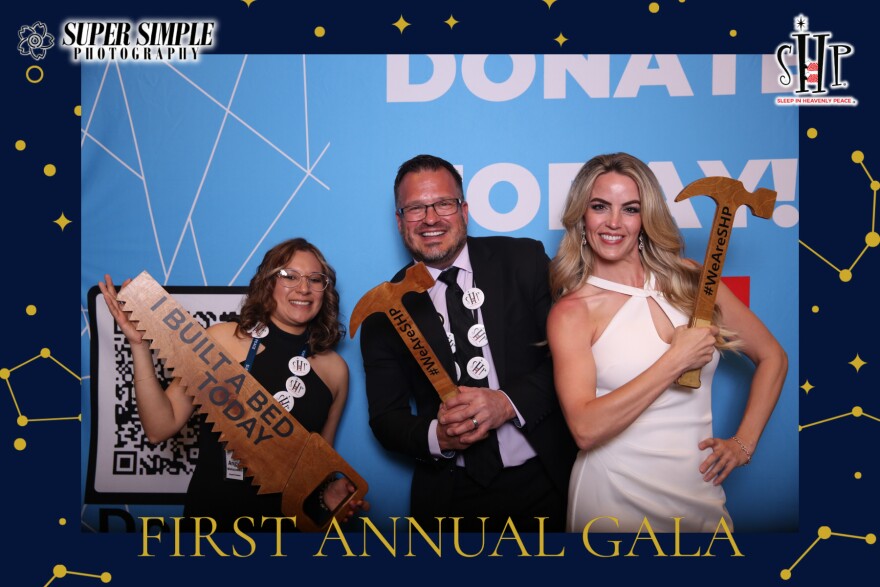 From left to right, Angie Mahaiuddin; Reno Chapter President, Luke Mickelson; SHP Founder and Belinda Mickelson, all holding wooden props.