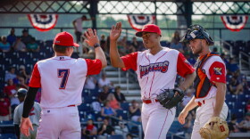  Two baseball players high-five on a field