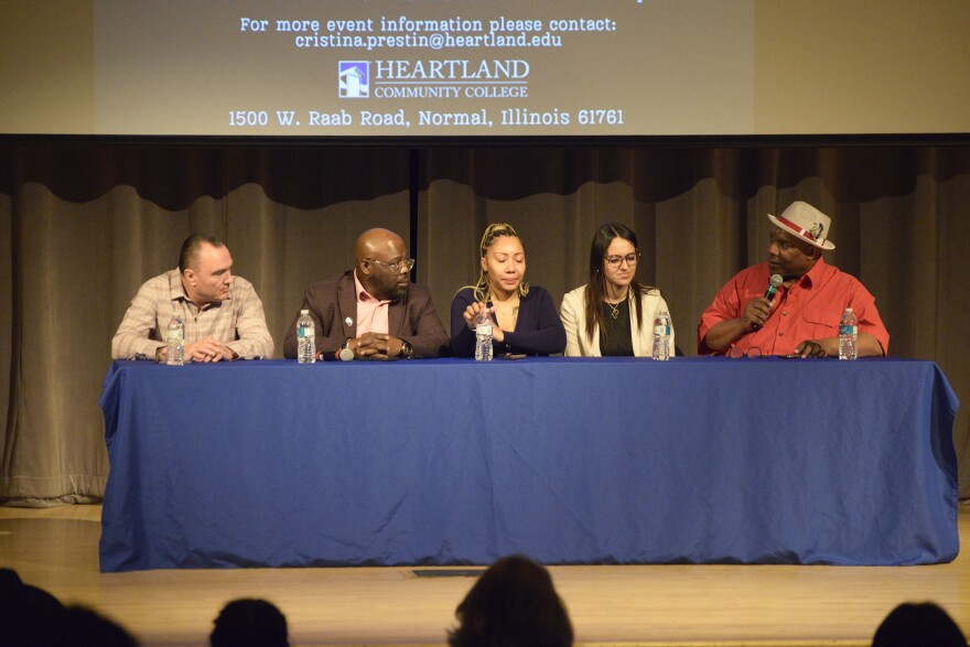 Five panelists on stage at an event