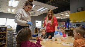 Two workers help a group of 3-year-old children at Hope Learning Center, the only licensed child care facility in Lucas County, Iowa.