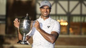 Aaron Rai, of England, poses with the trophy after winning the Wyndham Championship golf tournament in Greensboro, N.C., Sunday, Aug. 11, 2024. (AP Photo/Chuck Burton)