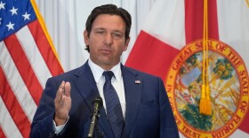 Gov. Ron DeSantis speaks from a podium 