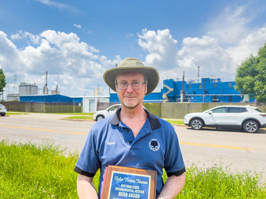 Dylan Keenan, a former lead air pollution permit engineer with the New York State Department of Environmental Conservation, holds up an award outside the Goodyear Tire and Rubber factory on 56th Street in Niagara Falls, NY on June 29, 2026.