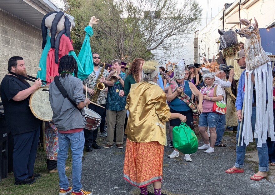 The Blue Tavern's Carrie Hamby (in the gold jacket with her back to the camera) attempts to "organize" the celebrants as parade time draws near.