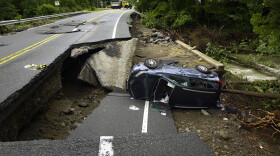 A damaged car lays on a collapsed roadway along Route 32 in the Hudson Valley near Cornwall, N.Y., Monday, July 10, 2023. Heavy rain has washed out roads and forced evacuations in the Northeast as more downpours were forecast throughout the day.