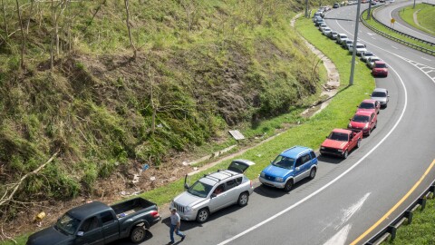 A line of cars stretches for a mile at the Gulf Route 65 gas station in Rio Grande, Puerto Rico, as people wait for a gasoline tanker, scheduled to arrive with fuel sometime Monday.