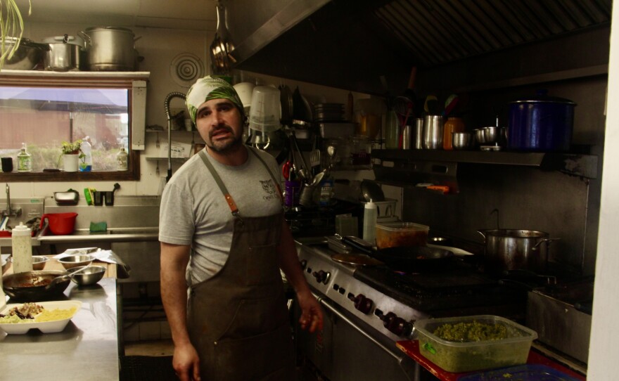 The owner of Falafelove, Avishai Leibson, cooks chicken, falafel, and other treats inside the restaurant's kitchen.