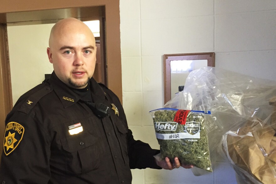 In the evidence room at the courthouse in Deuel County, Neb., Sheriff Adam Hayward holds up a 1-pound bag of marijuana confiscated during a recent traffic stop.