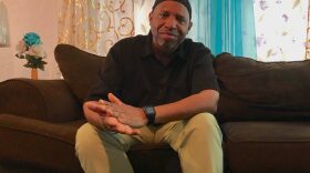 Aubrey Strong sits on the living room couch in the home he shares with his fiancee, Keosha Burke, her daughter, Keona, and his daughter, Kelsey. (Danielle Ivanov/WUFT News)