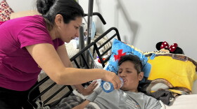 Luz Janet Linares (izquierda) ayuda a su esposo, Silvano Camis (derecha), a beber agua en su residencia de Hartford.