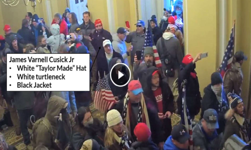 Federal criminal complaints allege that James Cusick Jr., in the white cap; Casey Cusick, in the red cap behind him; and David John Lesperance, in the blue cap with a red cellphone, can be seen on surveillance video inside the U.S. Capitol on Jan. 6. Image: DOJ