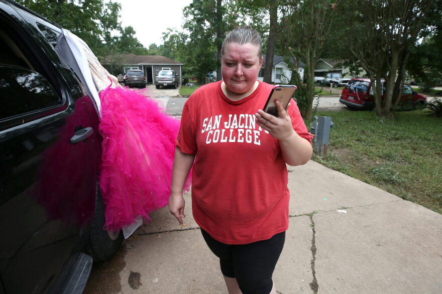 Geri-Ann Hernandez talks on the phone with the car insurance company for her Toyota Camry. She says the company told her it’s probably totaled. (Jorge Sanhueza-Lyon/KUT)