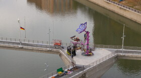 A crew installs the new city-mark-themed sculpture on the Sister Cities Bridge in downtown Rochester.