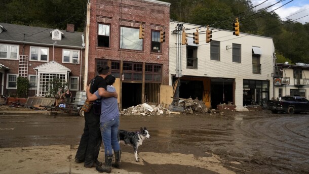 Resident Anne Schneider, right, hugs her friend Eddy Sampson as they survey damage caused by Hurricane Helene, Oct. 1, 2024, in Marshall, N.C.